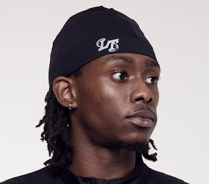 Man wearing a black headwrap with a logo on a plain background